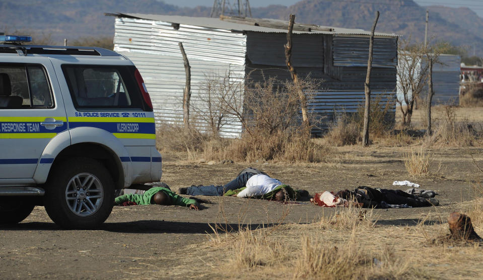 Bodies of striking miners lay on the ground after police opened fire on a crowd at the Lonmin Platinum Mine near Rustenburg, South Africa, Thursday, Aug. 16, 2012. South African police opened fire Thursday on a crowd of striking workers at a platinum mine, leaving an unknown number of people injured and possibly dead. Motionless bodies lay on the ground in pools of blood. (AP Photo)