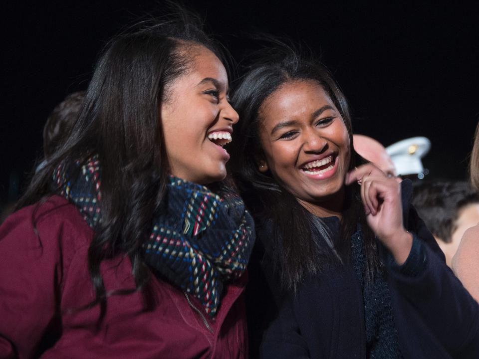 Malia (L) and Sasha (C) share a laugh on the Ellipse of the National Mall December 3, 2015 in Washington, DC