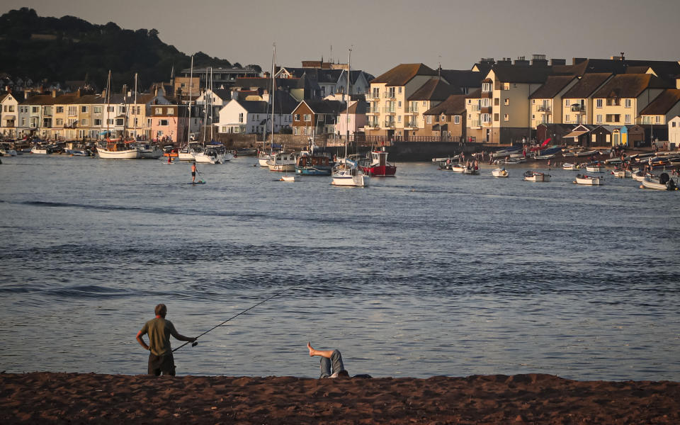 A man fishes in the Teign estuary in Shaldon, Devon, England, Wednesday July 21, 2021. (AP Photo/Tony Hicks)