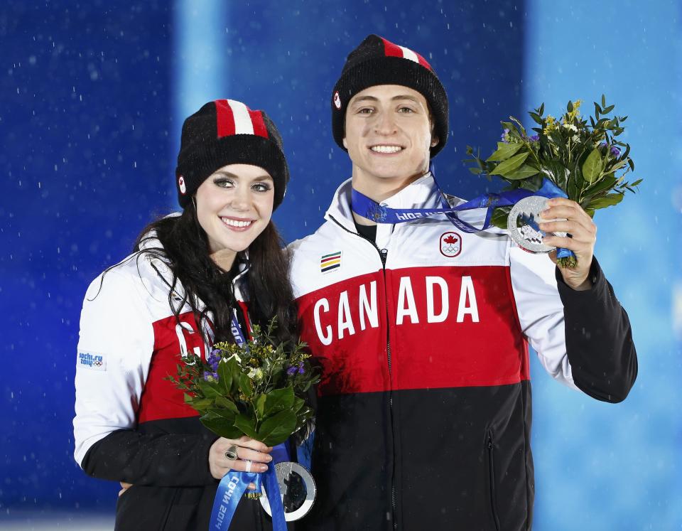 Silver medallists Canada's Tessa Virtue and Scott Moir celebrate during the medal ceremony for the figure skating ice dance free dance program at the 2014 Sochi Winter Olympics February 18, 2014. REUTERS/Shamil Zhumatov (RUSSIA - Tags: OLYMPICS SPORT FIGURE SKATING)