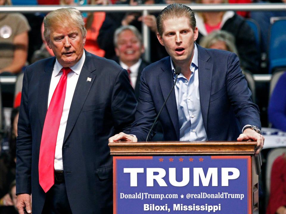 Donald Trump listens as Eric Trump speaks during a rally in Biloxi, in 2016.