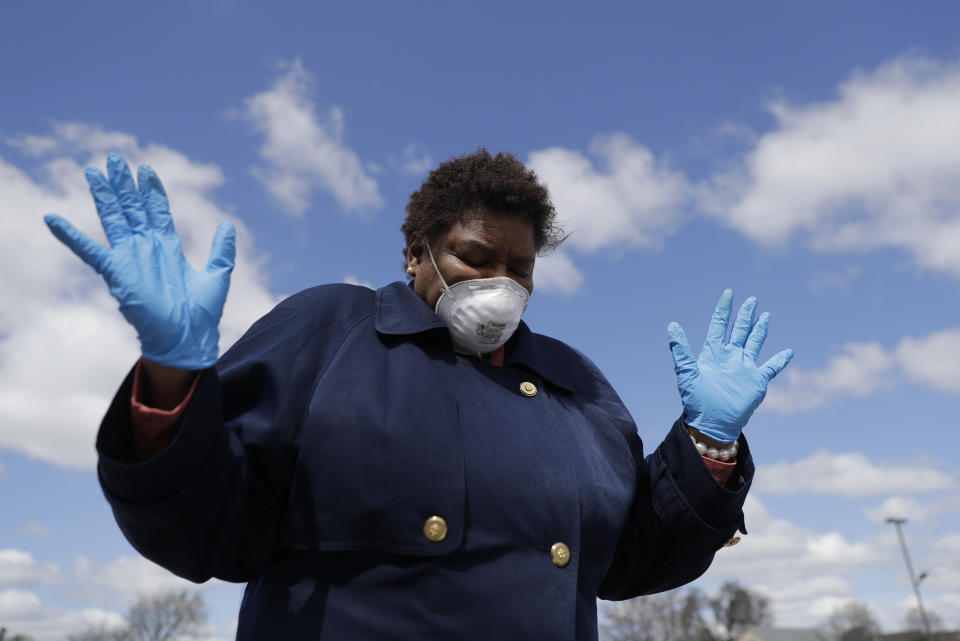 Deborah Harrison prays during a drive-thru Holy Communion on Good Friday at Grace Apostolic Church, Friday, April 10, 2020, in Indianapolis. The new coronavirus causes mild or moderate symptoms for most people, but for some, especially older adults and people with existing health problems, it can cause more severe illness or death. (AP Photo/Darron Cummings)