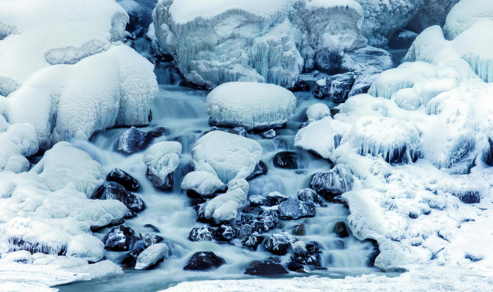 Water flows over ice forming at the base of the American Falls, viewed from the Canadian side in Niagara Falls, Ontario, Canada, Jan. 3, 2018.