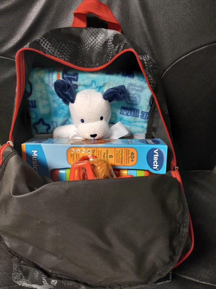 A backpack filled with toys, coloring books, books and other items. Averie Walkley, 8, donated these items to the children of women who live at A Place to Call Home, a transitional home for women operated by Catholic Charities of Tompkins/ Tioga Counties.