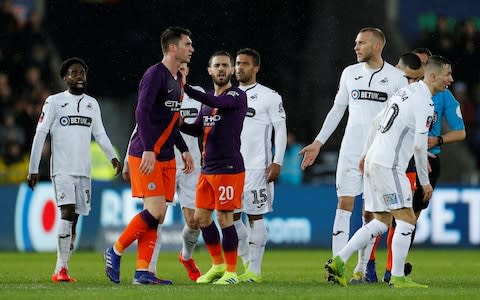 Manchester City's Aymeric Laporte clashes with Swansea City players at half time - Credit: REUTERS