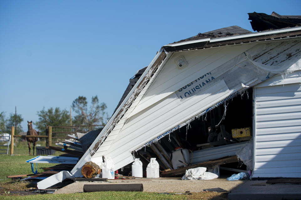 A garage partially destroyed by Hurricane Laura has the word, "Louisiana" written on it. The eye of Hurricane Delta came over this area in southwest Louisiana on Saturday, Oct. 10, 2020. (Chris Granger/The Advocate via AP)