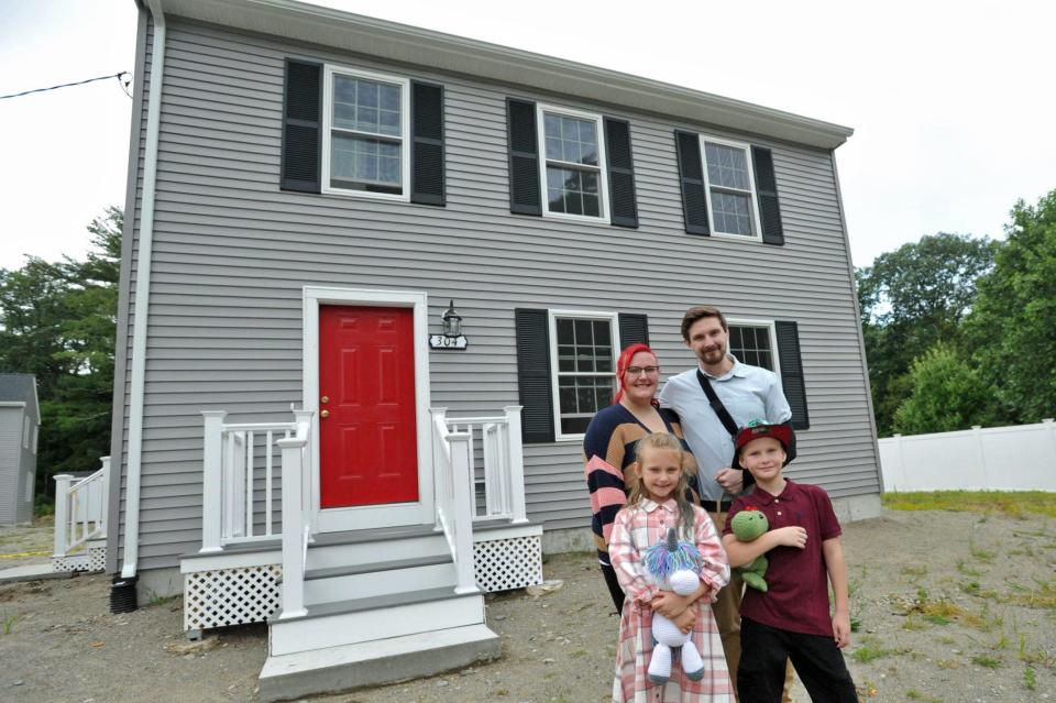Sara and Brendan O'Donnell and their twin 7-year-olds, Briley, left, and Connor, stand in front of their new Habitat for Humanity home in Hingham.