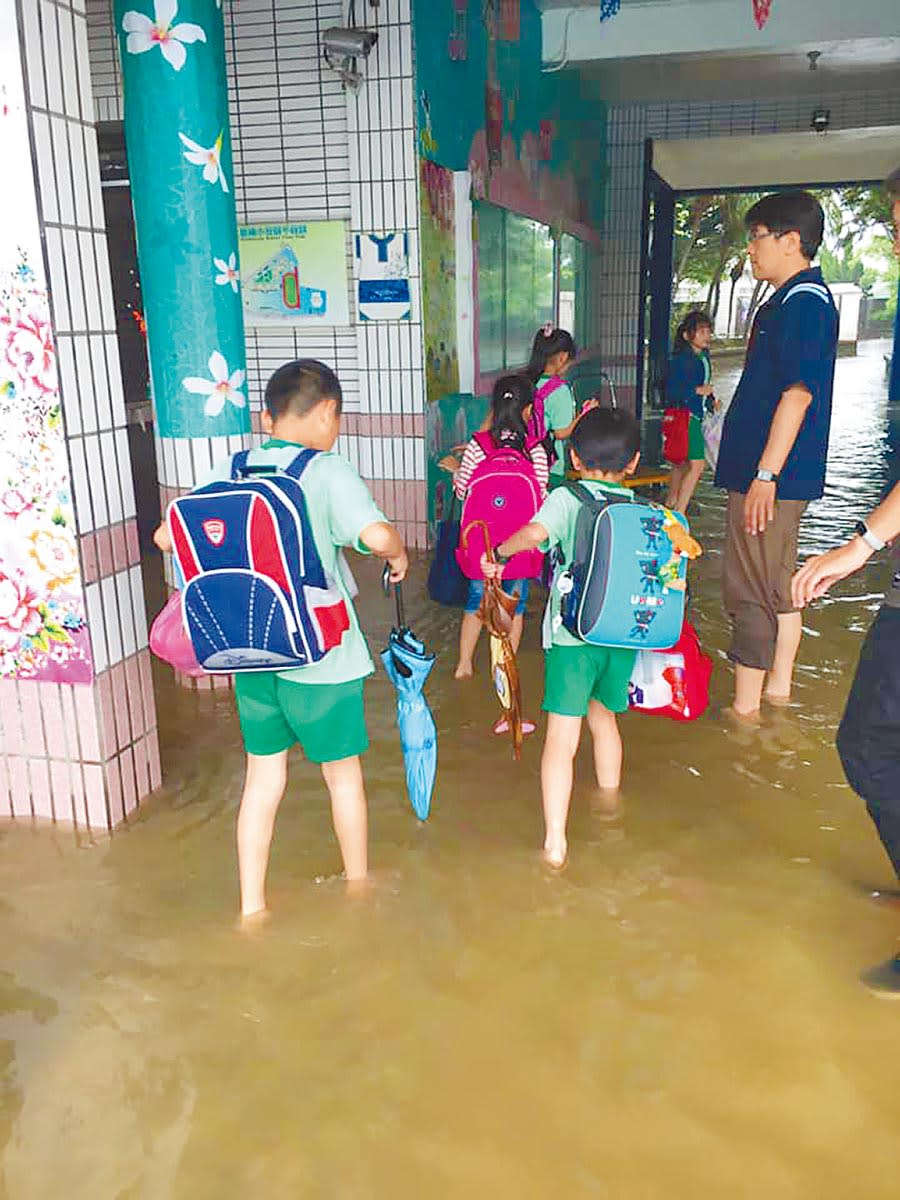 新屋區大坡國小因大雨淹水，學童涉水上課。（校方提供）