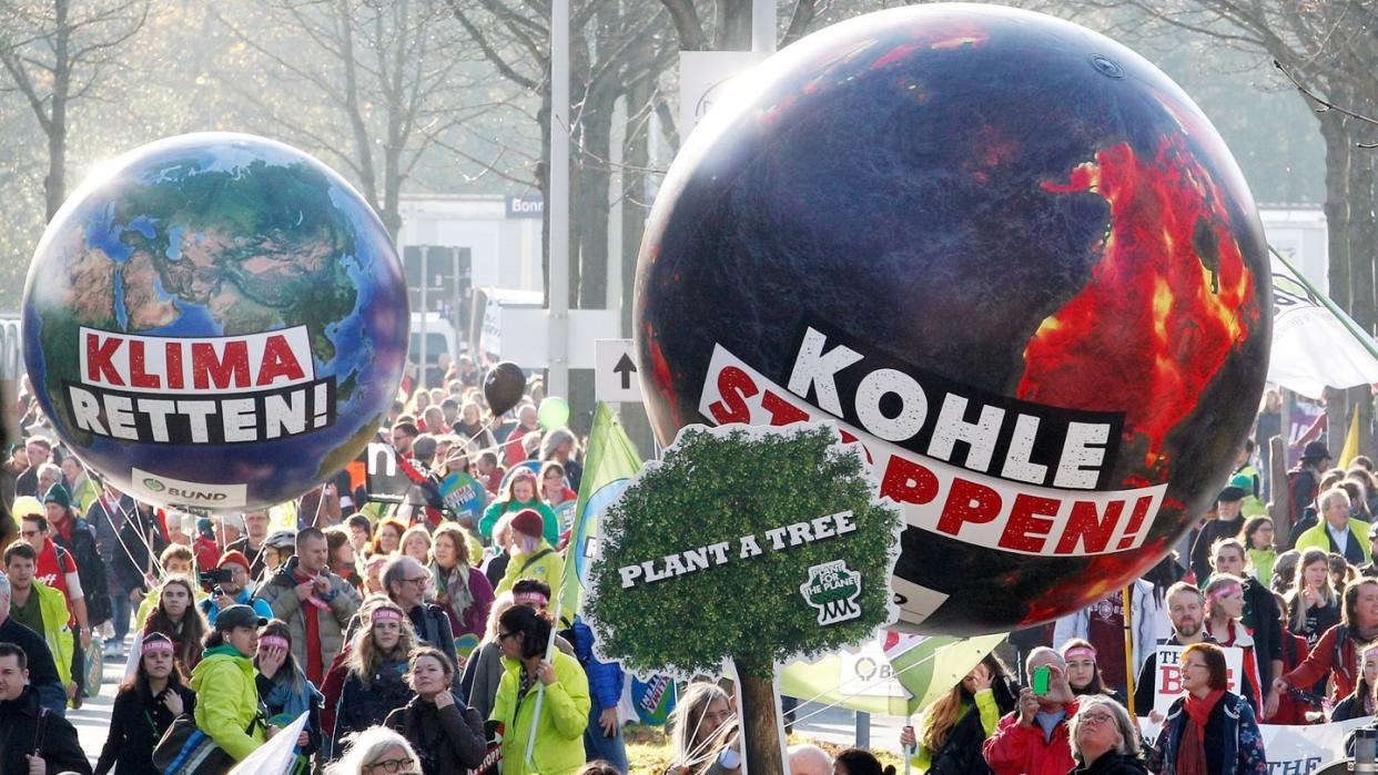 Demonstranten fordern in Bonn mit einem Modell der Erdkugel mit der Aufschrift "Klima retten" und einer weiteren mit der Aufschrift "Kohle stoppen" die Umsetzung des Weltklimaabkommens.
