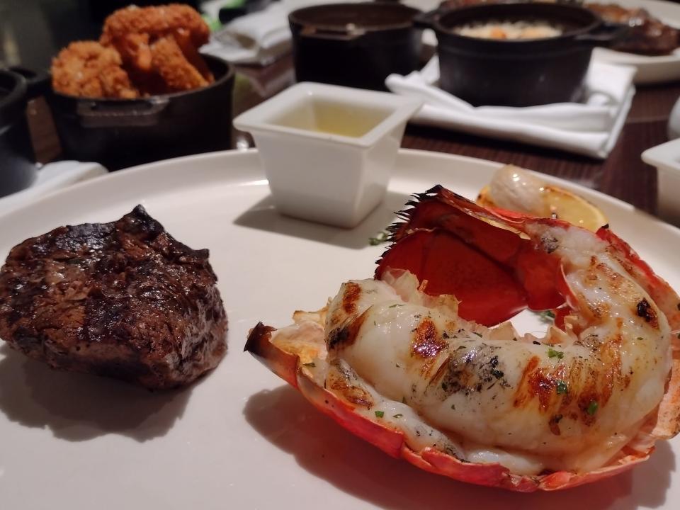 A plate with a lobster tail and a steak.