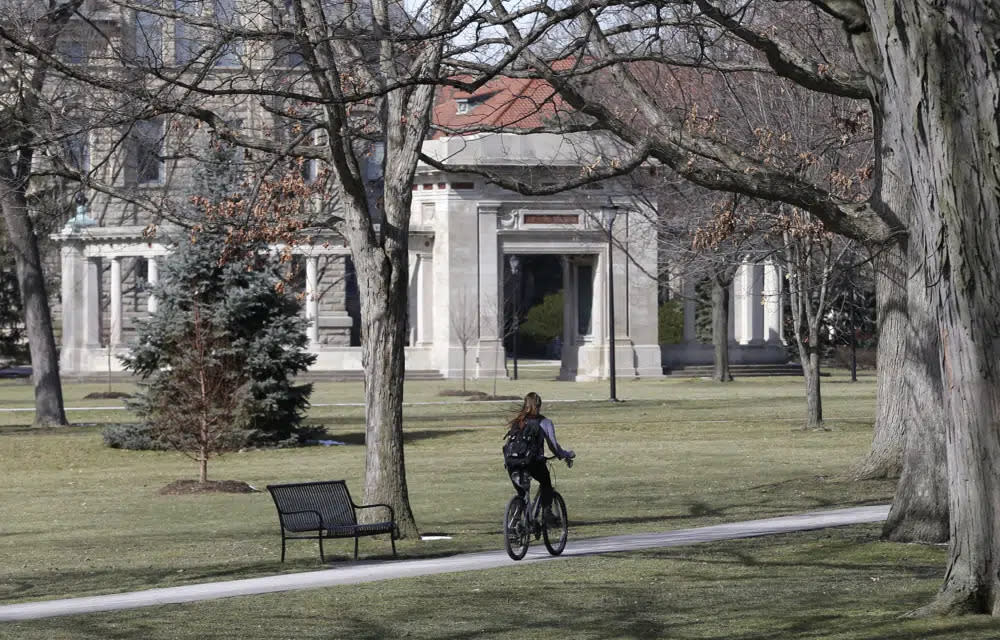 A student rides a bicycle on the campus of Oberlin College in Oberlin, Ohio, March 5, 2013. (AP Photo/Tony Dejak, File)