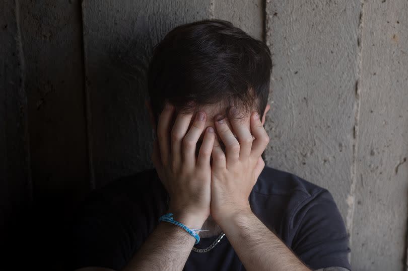 A student sits outside on campus trying to cope with being mentally burnt out. He feels as though he is in a dark place.