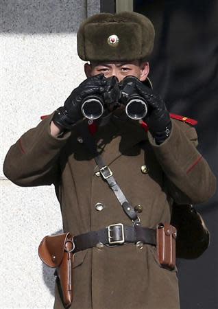 A North Korean soldier, with a pair of binoculars, observes activity in the south of the truce village of Panmunjom in the demilitarised zone separating the two Koreas, north of Seoul February 6, 2014.REUTERS/Han Jae-ho/News1