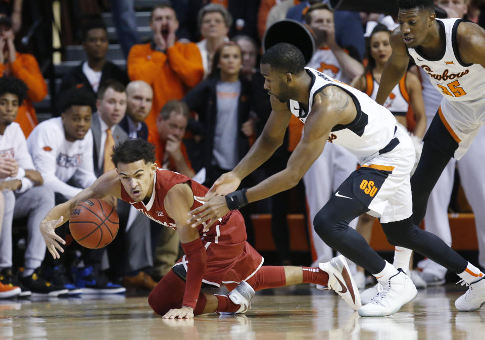 Oklahoma guard Trae Young left, keeps the ball from Oklahoma State guard Tavarius Shine, center, in the first half of an NCAA college basketball game in Stillwater, Okla., Saturday, Jan. 20, 2018. (AP Photo/Sue Ogrocki)