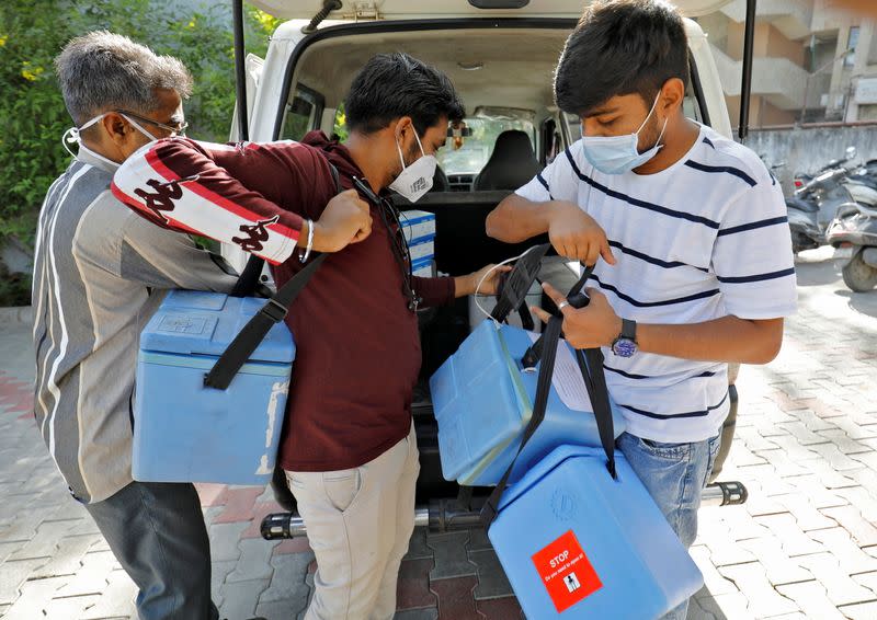 Healthcare workers unload boxes containing vials of COVISHIELD, a coronavirus disease (COVID-19) vaccine, in Ahmedabad