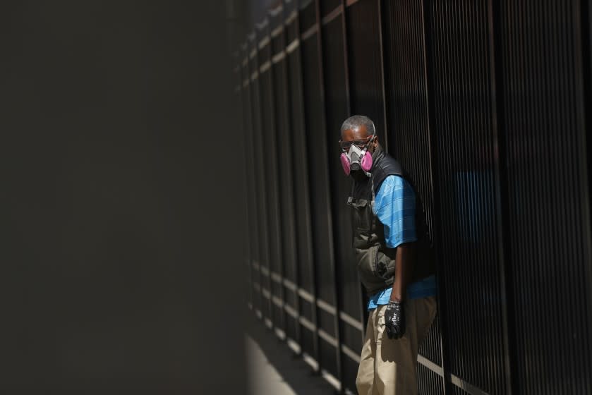 A man in Detroit wears a protective mask while waiting for a bus.