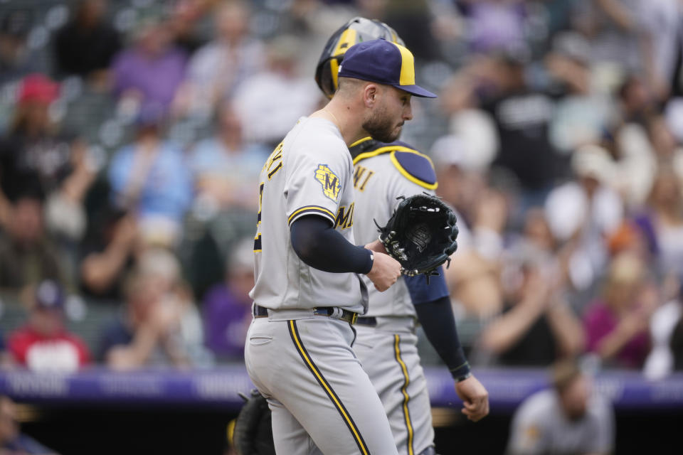 Milwaukee Brewers relief pitcher Peter Strzelecki, foreground, pounds his glove after giving up a single to Colorado Rockies pinch-hitter Harold Castro to allow in two runs in the eighth inning of a baseball game Thursday, May 4, 2023, in Denver. (AP Photo/David Zalubowski)