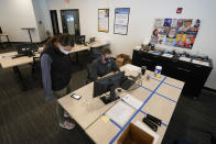 Brad Bowman and Mikela Earley review an order for a customer who is inside of the bubble while in town for the NCAA men's college basketball tournament, Tuesday, March 30, 2021, in Indianapolis. The NCAA and local organizing groups set up expanded ambassador and item-delivery services relying on volunteer help to take care of needs for players, officials and others working inside. (AP Photo/Darron Cummings)