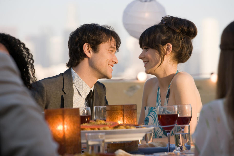 Joseph Gordon-Levitt and Zooey Deschanel stare at each other at dinner