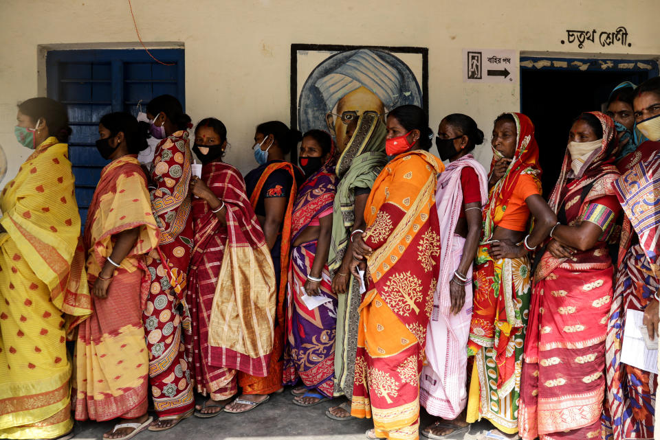 Voters stand in a queue to cast their votes during the first phase of elections in West Bengal state in Pirakata, India, Saturday, March 27, 2021. Voting began Saturday in two key Indian states with sizeable minority Muslim populations posing a tough test for Prime Minister Narendra Modi’s popularity amid a months-long farmers’ protest and the economy plunging with millions of people losing jobs because of the coronavirus pandemic. (AP Photo/Bikas Das)