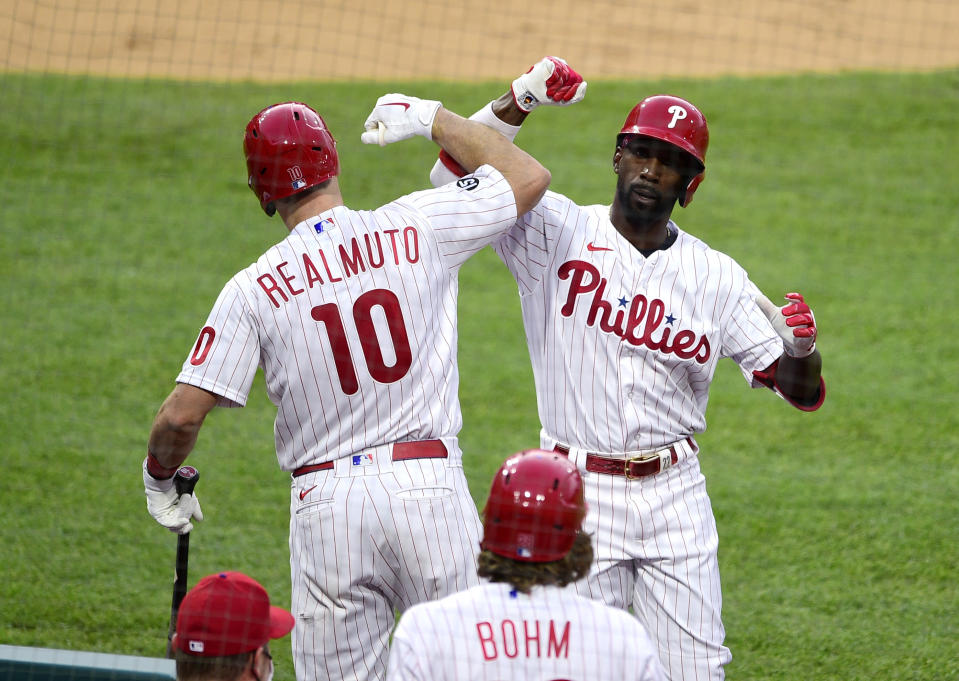 Philadelphia Phillies' Andrew McCutchen, right, celebrates with J.T. Realmuto after McCutchen hit a solo home run during the first inning of a baseball game, Tuesday, May 4, 2021, in Philadelphia. (AP Photo/Derik Hamilton)