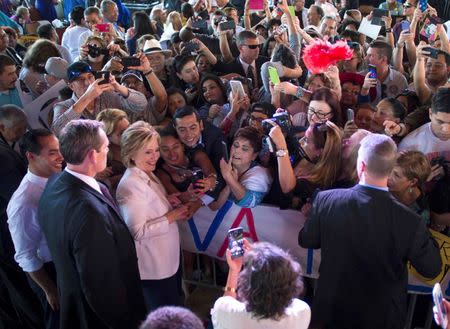 Democratic U.S. presidential candidate Hillary Clinton greets the crowd with U.S. Secretary of Housing and Urban Development Julian Castro (FarL) during a "Latinos for Hillary" rally in San Antonio, Texas October 15, 2015. REUTERS/Darren Abate