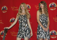 Singer and songwriter Taylor Swift (R) smiles as she poses with her wax likeness during an unveiling of the statue at Madame Tussauds in New York, October 27, 2010. REUTERS/Mike Segar