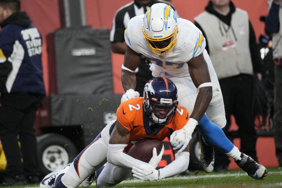 Broncos cornerback Pat Surtain II (2) intercepts a pass in the end zone in front of Chargers tight end Jared Cook.