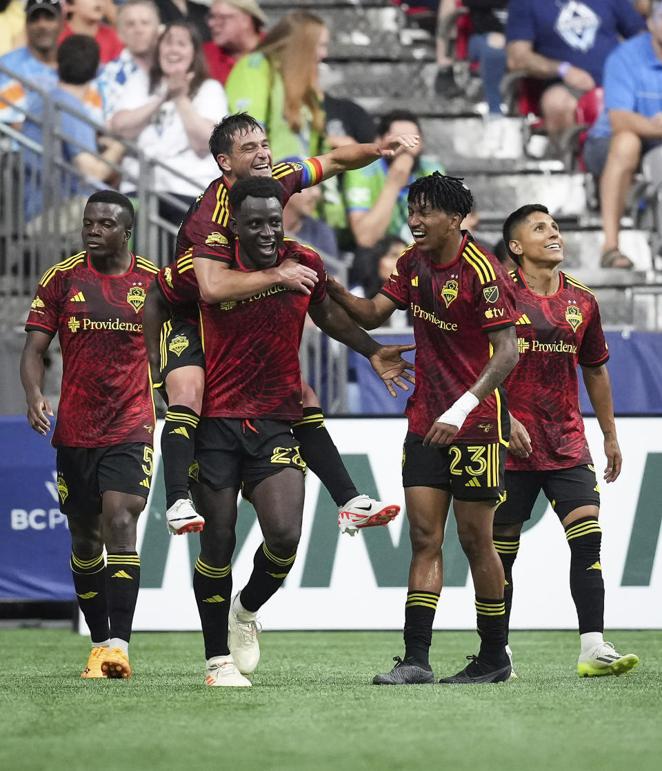 Seattle Sounders' Nouhou Tolo, Nicolas Lodeiro, back, Yeimar Gomez, Leo Chu and Raul Ruidiaz, from left, celebrate Gomez's goal against the Vancouver Whitecaps during the second half of an MLS soccer match Saturday, July 8, 2023, in Vancouver, British Columbia. (Darryl Dyck/The Canadian Press via AP)