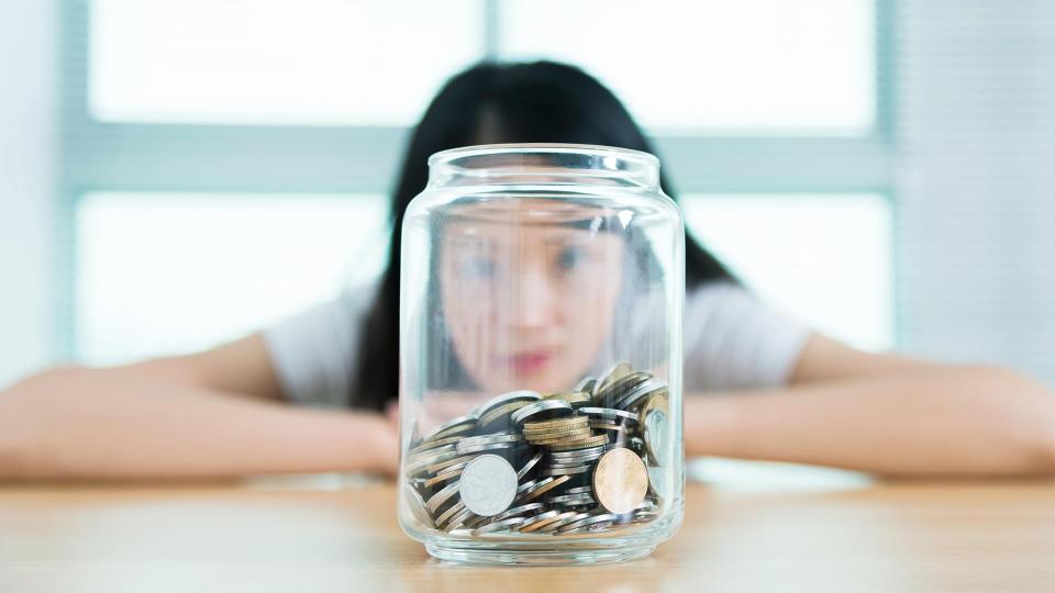 The woman hid behind a jar full of coins.