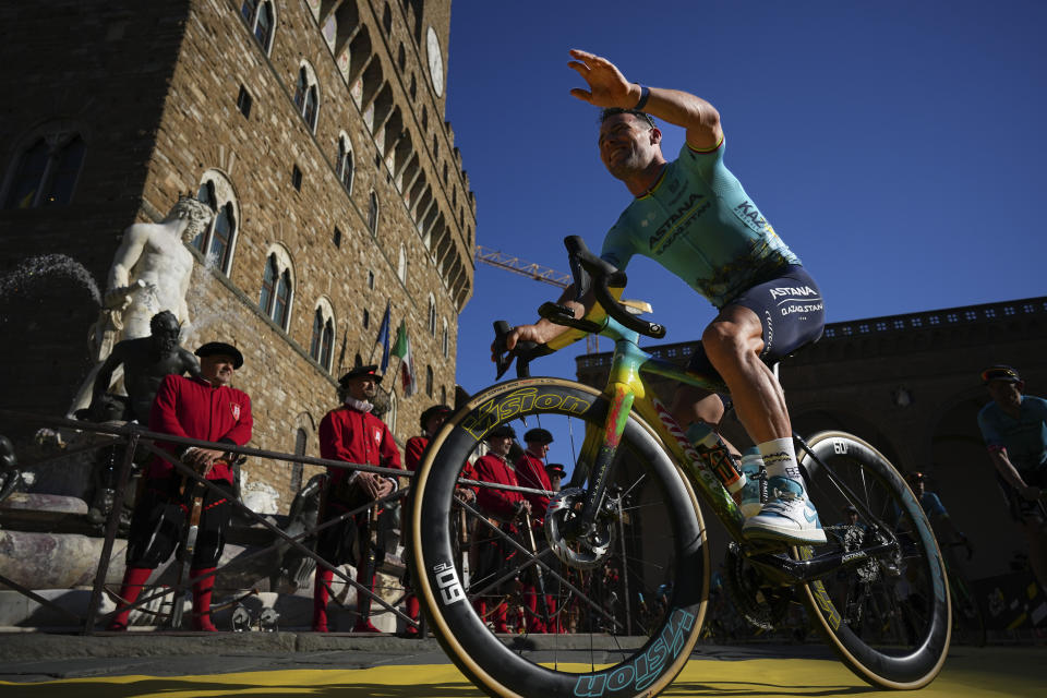 Britain's Mark Cavendish greets spectators as he arrives for the team presentation in Florence, Italy, Thursday, June 27, 2024, two days before the start of the Tour de France cycling race. (AP Photo/Daniel Cole)