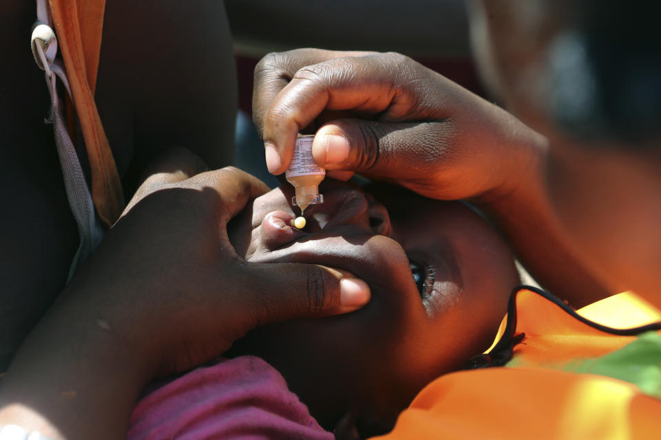 A baby receives an oral cholera vaccination at a camp for displaced survivors of cyclone Idai in Beira, Mozambique, Wednesday, April, 3, 2019. A cholera vaccination campaign is kicking off to reach nearly 900,000 cyclone survivors in Mozambique as officials rush to contain an outbreak of the disease. (AP Photo/Tsvangirayi Mukwazhi)