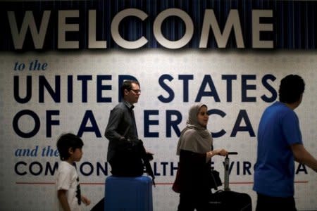 FILE PHOTO: International passengers arrive at Washington Dulles International Airport after the U.S. Supreme Court granted parts of the Trump administration's emergency request to put its travel ban into effect later in the week pending further judicial review, in Dulles, Virginia, U.S., June 26, 2017. REUTERS/James Lawler Duggan/Files