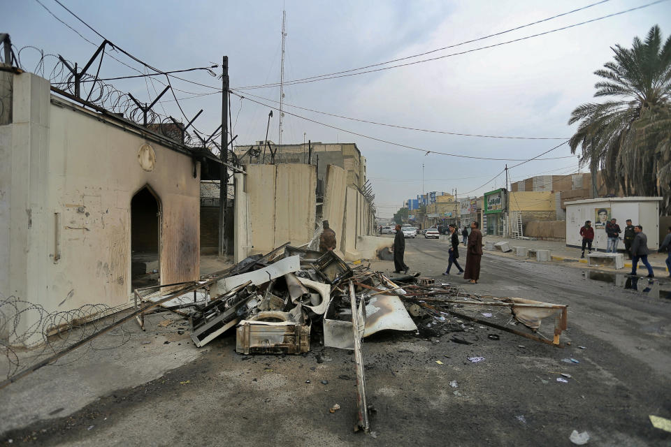 Security forces and civilians gather near the burned Iranian consulate in Najaf, Iraq, Thursday, Nov. 28, 2019. An Iraqi police official says anti-government protesters have burned down the Iranian consulate in southern Iraq late Wednesday. Protesters torched the Iranian consulate building in the holy city of Najaf, the seat of the country's Shiite religious authority. Iranian staff working in the consulate escaped through the back door and were not harmed. (AP Photo/Anmar Khalil)