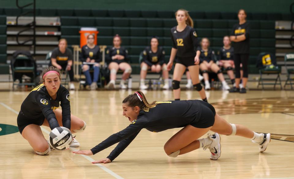 Garfield’s Gabby Barnard (right) and Madeline Shirkey (left) dive for the ball to keep a volley alive during Wednesday night’s Division III District Semifinal game against Lake Center Christian High School in Medina.