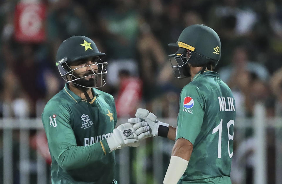 Pakistan's Asif Ali, left, celebrates with partner Pakistan's Shoaib Malik after hitting two consecutive six during the Cricket Twenty20 World Cup match between New Zealand and Pakistan in Sharjah, UAE, Tuesday, Oct. 26, 2021. (AP Photo/Aijaz Rahi)