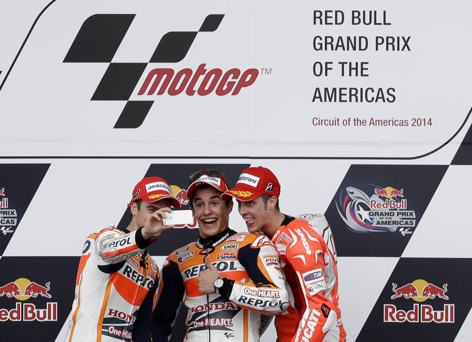 Dani Pedrosa, from left, of Spain, Marc Marquez of Spain, and Andrea Dovizioso, right, of Italy shoot a selfie of themselves on the winners podium following the Grand Prix of the Americas MotoGP motorcycle race, Sunday, April 13, 2014, in Austin, Texas. Marquez won the race, with Pedrosa and Dovizioso in second and third respectively. (AP Photo/Tony Gutierrez)