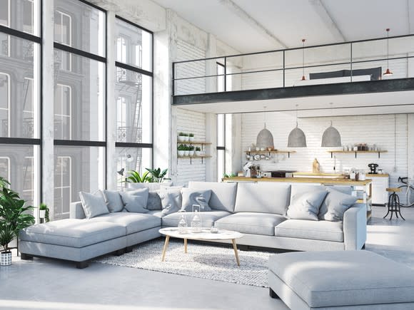 Large, brightly lit apartment with a seating area consisting of sofas.