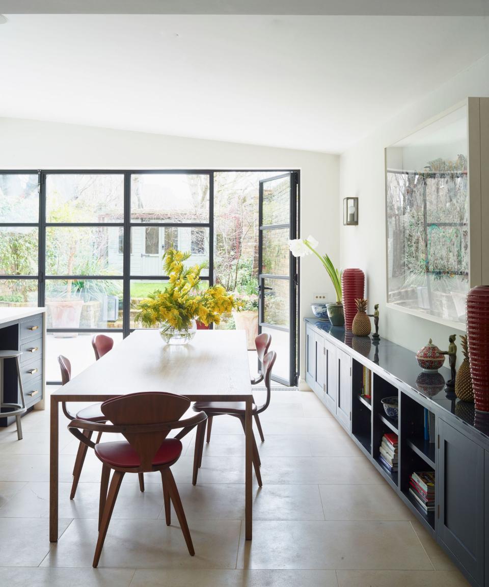 Red chair and pots, blue cabinets, wooden table