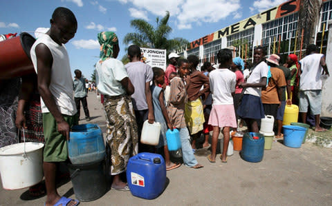 People queue for water during a cholera outbreak in Zimbabwe in 2008. Critics say Mr Mugabe has overseen the decay of the country's healthcare system since he came to power n 1980 - Credit: AARON UFUMELI/EPA