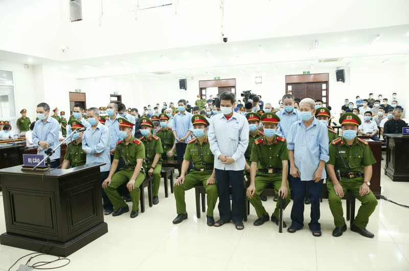 Farmers of Dong Tam village stand between police during court verdict in Hanoi