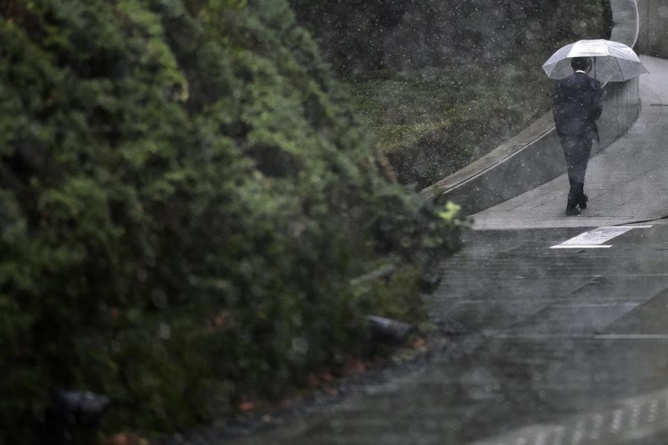 A person walks at a street in the snow Monday, Feb. 5, 2024, in Tokyo. Japan Meteorological Agency warns more metropolitan areas braced for snowfall Monday. (AP Photo/Eugene Hoshiko)