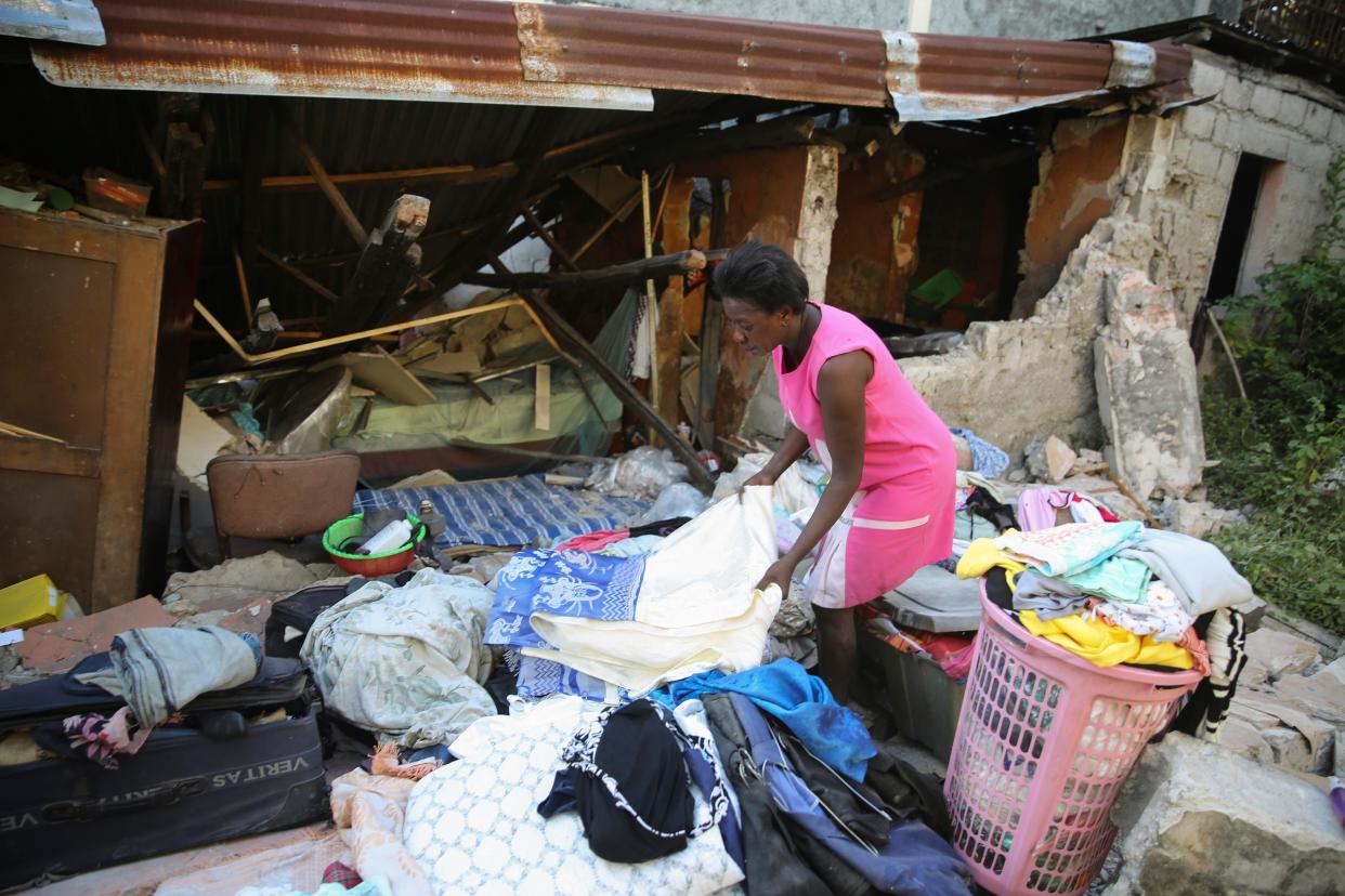 A woman recovers belongings from her home destroyed by the earthquake in Les Cayes, Haiti, Saturday, Aug. 14, 2021.