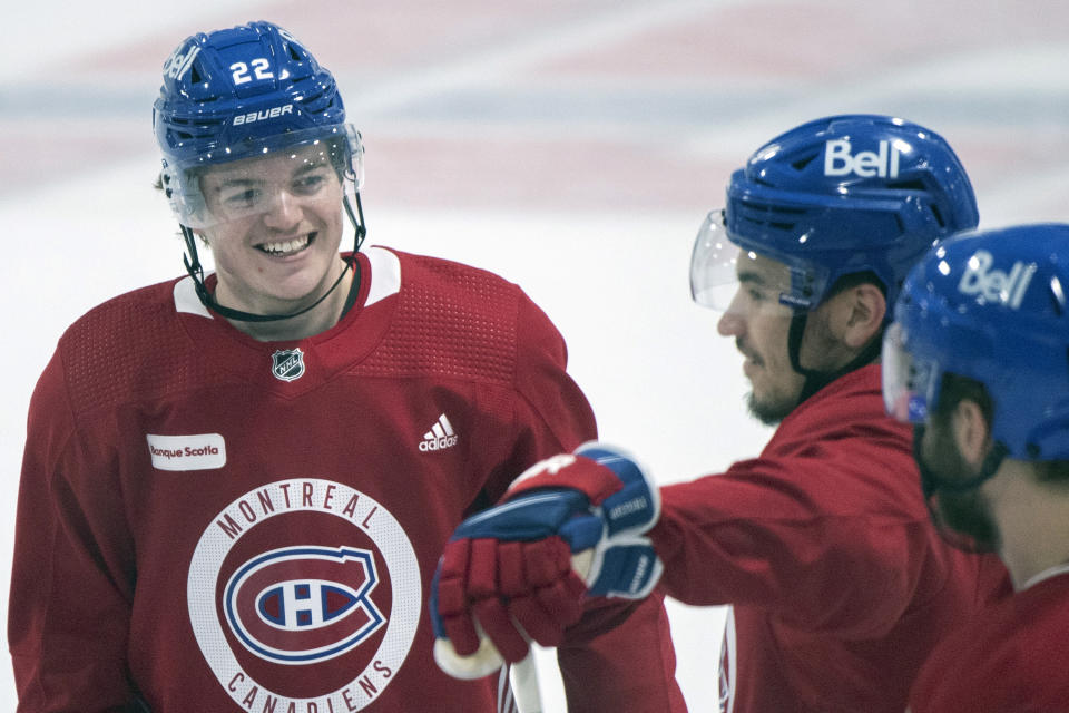 Montreal Canadiens' Cole Caufield (22) smiles as he talks with teammate Nick Suzuki (14) during practice in Brossard, Quebec, Sunday, June 27, 2021. The Canadiens take on the Tampa Bay Lightning in the NHL hockey Stanley Cup finals beginning Monday in Tampa, Fla. (Graham Hughes/The Canadian Press via AP)