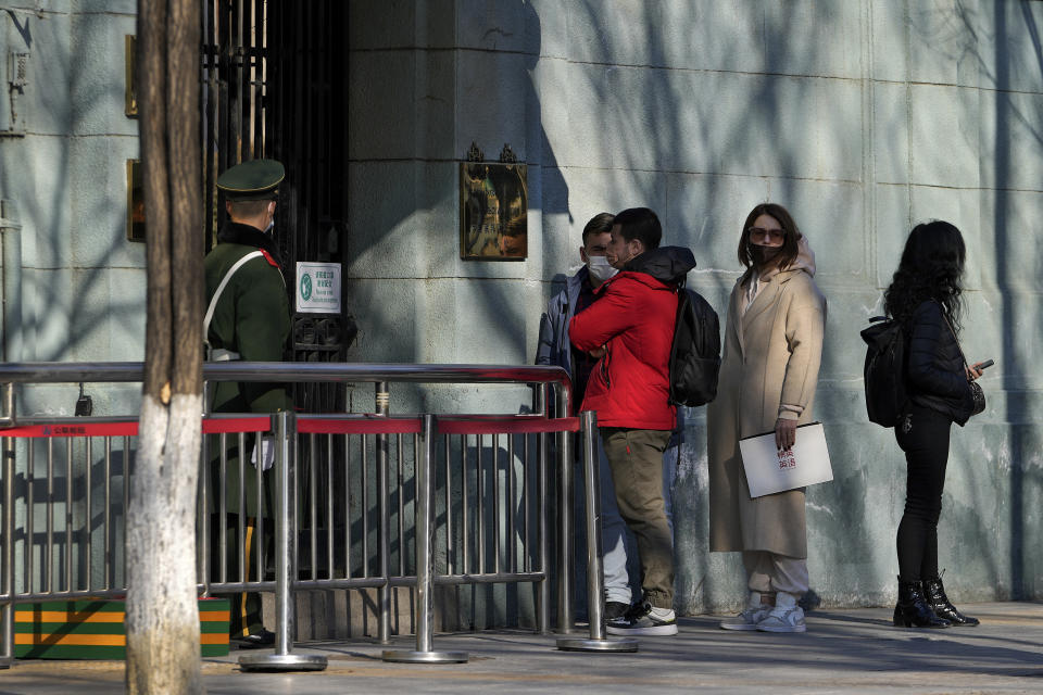 A Chinese paramilitary policeman stands watch as people wait to enter the Russian Embassy in Beijing, Thursday, Feb. 24, 2022. China repeated calls for talks to resolve the crisis in Ukraine on Thursday while refusing to criticize Russia's attack and accusing the U.S. and its allies of worsening the situation. (AP Photo/Andy Wong)