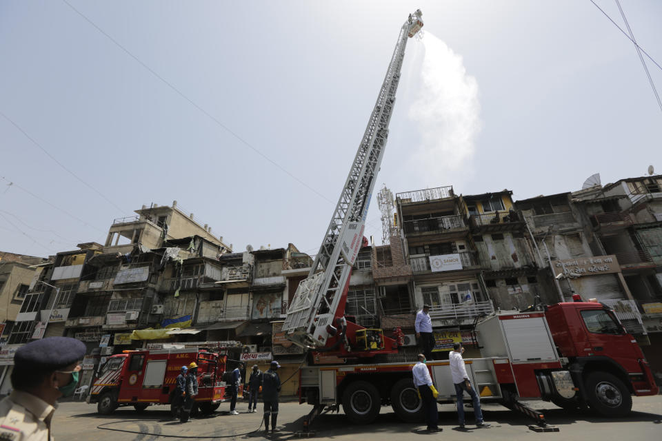 Indian firefighters use hydraulic platform to sanitize an area during lockdown to control the spread of the new coronavirus in Ahmedabad, India, Saturday, April 11, 2020. The new coronavirus causes mild or moderate symptoms for most people, but for some, especially older adults and people with existing health problems, it can cause more severe illness or death. (AP Photo/Ajit Solanki)