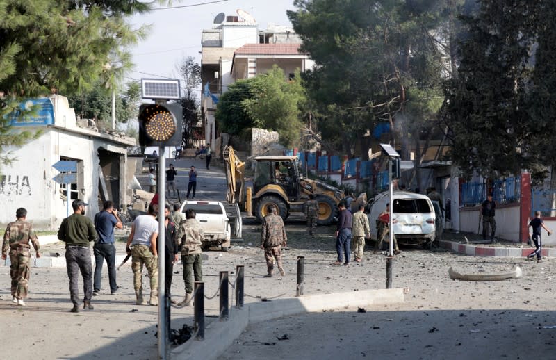 Turkey-backed Syrian rebel fighters inspect the site of an explosion in the town of Tal Abyad
