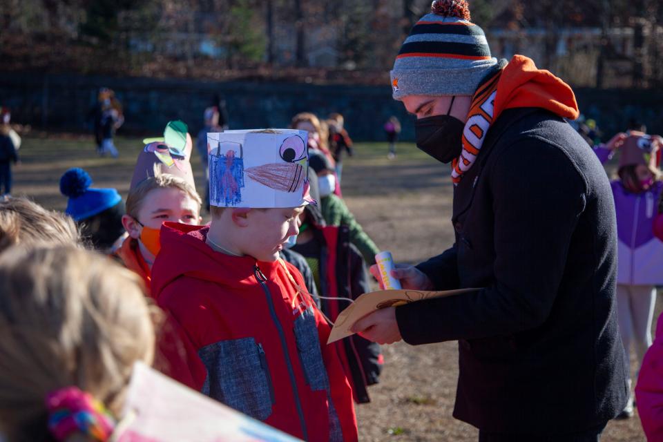 Gardner Mayor Michael Nicholson helps an Elm Street School second-grader secure his turkey hat to be worn during the Turkey Trot.