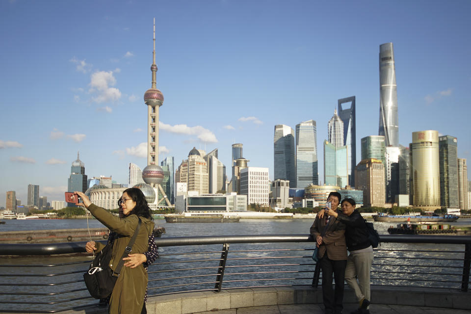 FILE - In this Nov. 12, 2020 file photo, people take selfies of the Pudong skyline as they stand on the Bund in Shanghai, China. A new study finds that cleaner air from the pandemic lockdown warmed the planet a bit in 2020, especially in places such as the eastern United States, Russia and China. Tuesday, Feb. 2, 2021 study found the pandemic lockdown reduced soot and sulfate air pollution, but those particles also reflect the sun's heat and help cool areas briefly. (AP Photo)