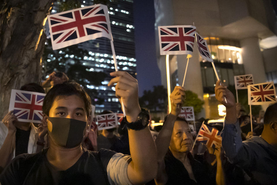 Demonstrators wave British flags during a rally outside of the British Consulate in Hong Kong, Wednesday, Oct. 23, 2019. Some hundreds of Hong Kong pro-democracy demonstrators have formed a human chain at the British consulate to rally support for their cause from the city's former colonial ruler. (AP Photo/Mark Schiefelbein)